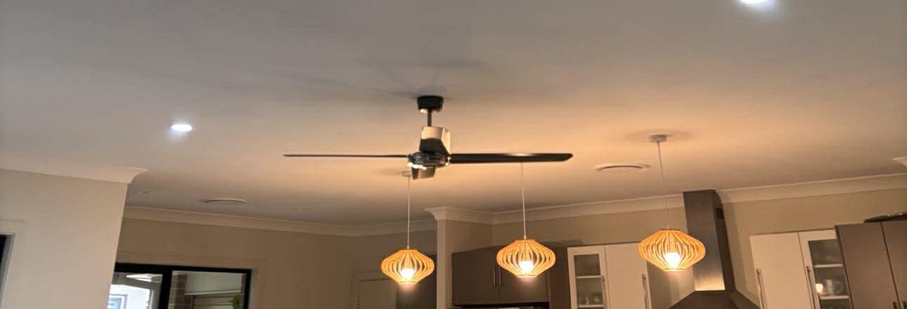 Three-blade ceiling fan installed in a Newcastle home, surrounded by LED downlights and pendant lighting, by Nate's Rates